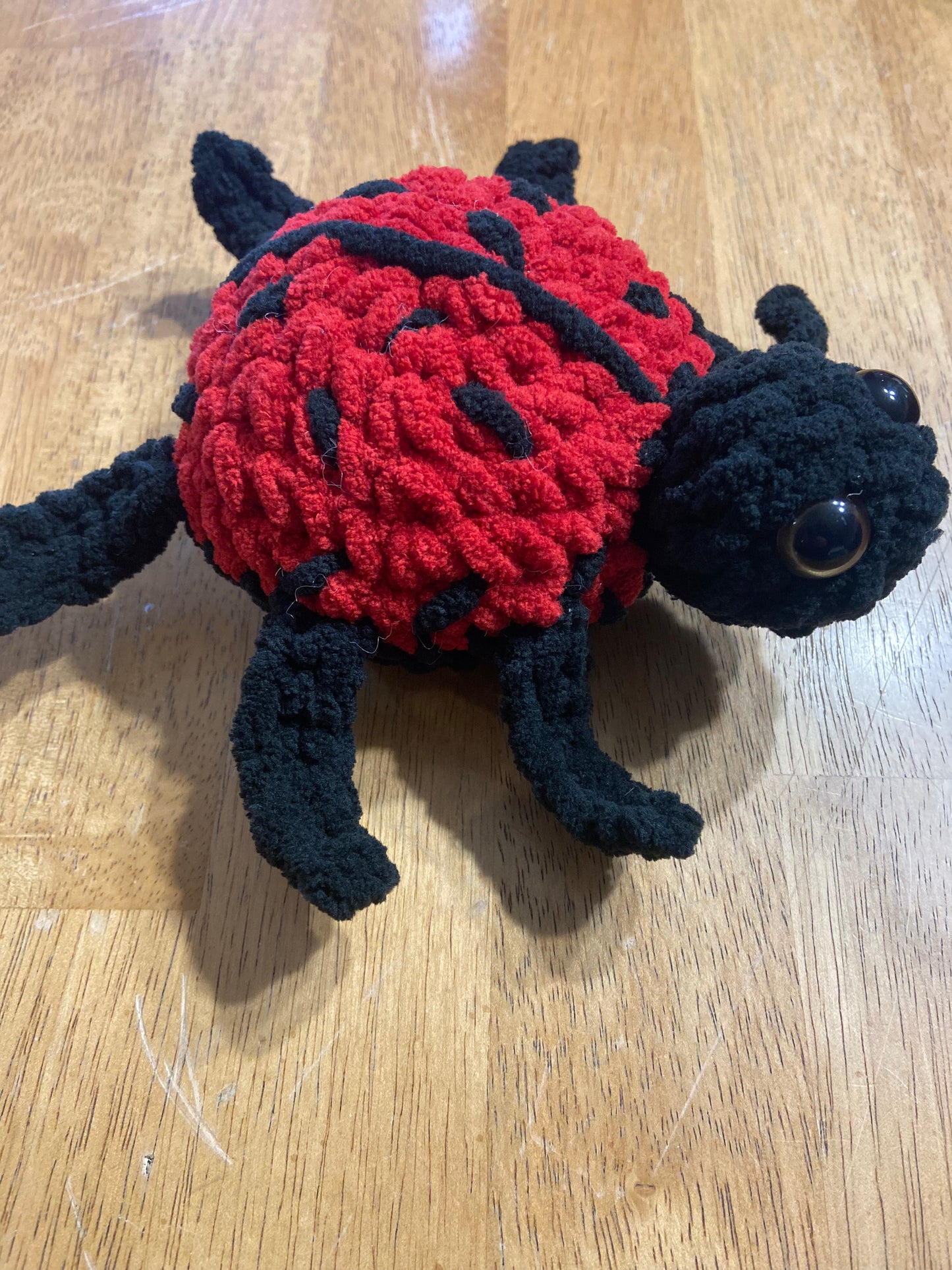 Handmade crochet ladybug plush toy with vibrant colors and intricate detailing.